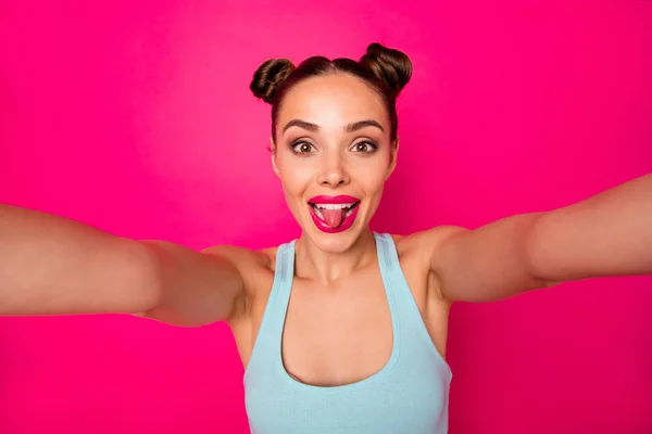 Mooie dame maken selfies steken tong uit de mond slijtage casual outfit geïsoleerd roze achtergrond — Stockfoto