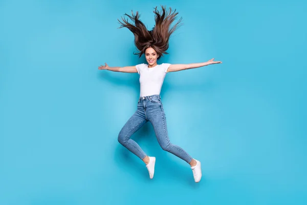Full längd foto av charmig tonåring höja händer hoppar isolerade över Blå bakgrund — Stockfoto