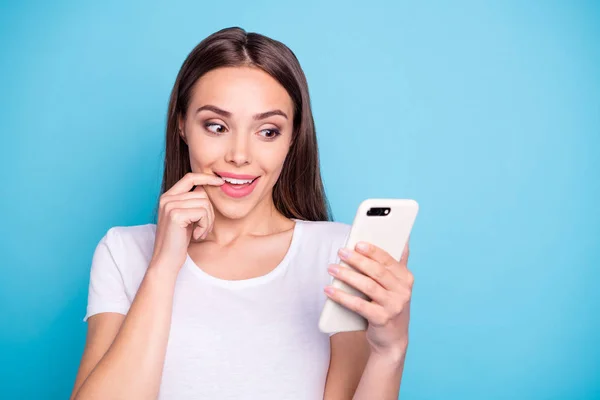 Close up foto de adolescente bonito inspirado olhando em sua tecnologia moderna ler novidades vestindo t-shirt branca isolada sobre fundo azul — Fotografia de Stock