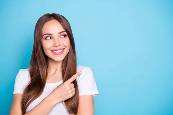 Foto de cerca de la encantadora juventud apuntando al espacio de copia mirando sonriente usando una camiseta blanca aislada sobre fondo azul — Foto de Stock