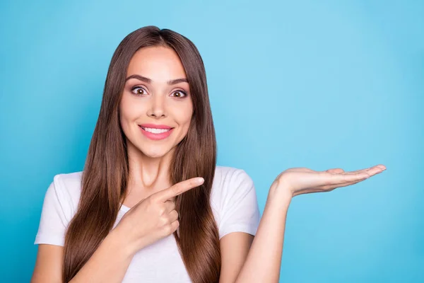 Cerrar uo foto de la linda juventud sosteniendo la mano mostrando anuncios con camiseta blanca aislada sobre fondo azul — Foto de Stock