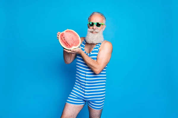 Retrato de pensionista jubilado en gafas de gafas con frutas tropicales exóticas con traje de baño a rayas aislado sobre fondo azul — Foto de Stock