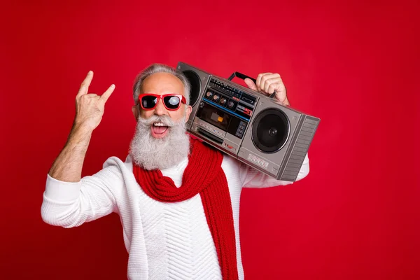 Rock chritmastime Portrait of crazy santa in eyeglasses eyewear screaming showing swag sign holding boom box wearing white sweater isolated over red background — Stock Photo, Image
