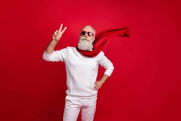 Trendy iyi giyimli santa karakter tarzı v-sign giyim güneş özellikleri örme giysiler izole kırmızı arka plan gösteren — Stok fotoğraf