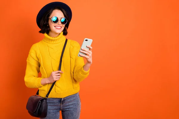 Foto copyspace di allegra bella fidanzata moderna lussuosa navigando attraverso il suo telefono in cerca di sconti e sconti mentre isolato con sfondo arancione — Foto Stock