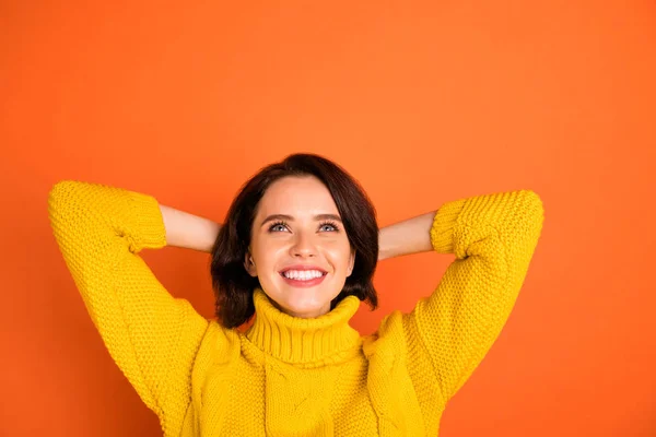 Photo rapprochée d'une belle fille rêveuse qui planifie quelque chose en attendant que cela se produise alors qu'elle est isolée avec un fond orange — Photo