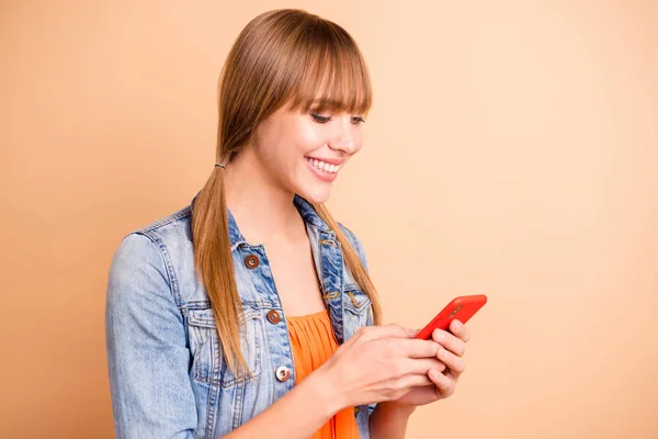 Bonita dama sosteniendo las manos del teléfono usan traje casual aislado de fondo beige — Foto de Stock