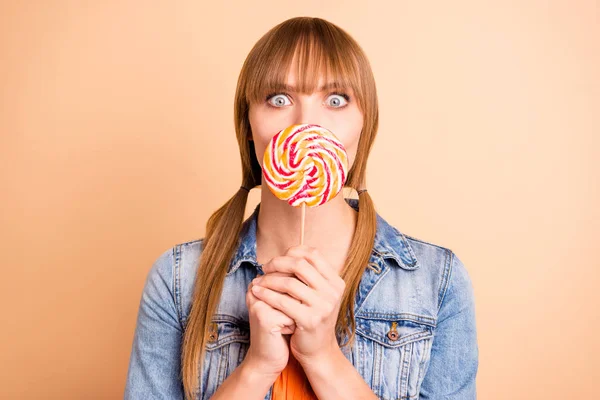Funky lady hiding mouth with big candy know rumours wear denim blazer isolated pastel beige background — Stock Photo, Image