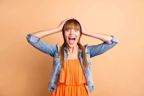 Portrait of cute astonished impressed teen teenager touch hands head scream shout incredible information wonder wear orange skirt dress isolated beige pastel background — Stock Photo, Image