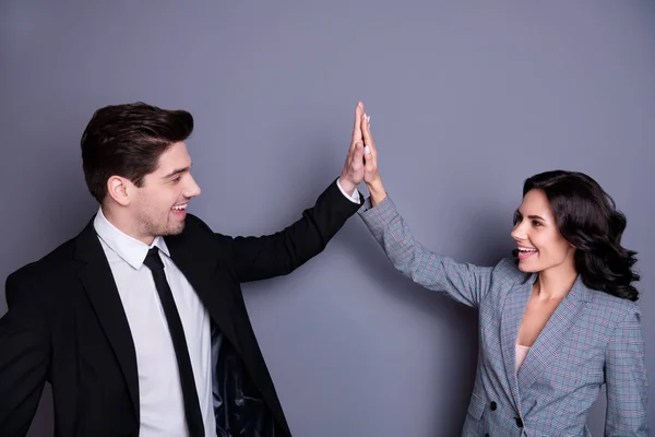 Profile side photo of cheerful wavy curly brunette haired couple giving high five wearing black jacket blazer isolated over grey background