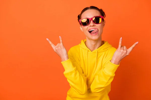 Retrato de adolescente fresco mostrando cuernos signo hacer caras con gafas gafas gafas aisladas sobre fondo naranja —  Fotos de Stock