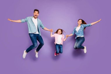 Full length photo of three rejoicing jumping high family members wear casual clothes isolated purple background clipart