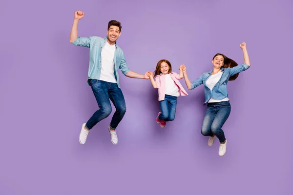 Full size photo of three jumping high family members celebrating good news wear casual clothes isolated purple background — Stock Photo, Image