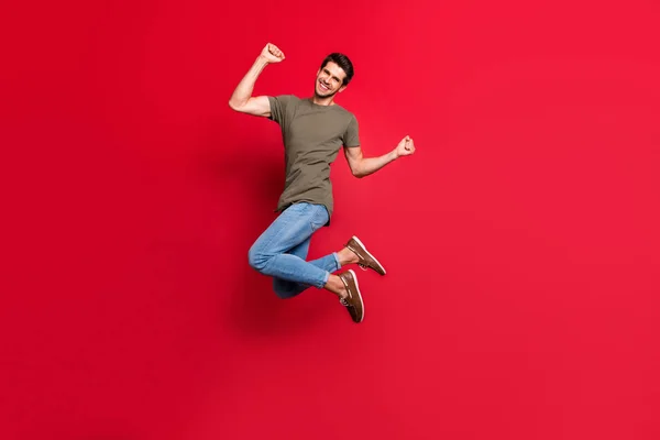 Pełne zdjęcie ciała niesamowity facet skoki wysokiej dziecinny nastrój nosić casual strój izolowane na czerwonym tle — Zdjęcie stockowe