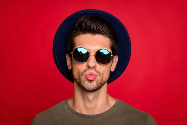 Foto di macho ragazzo invio aria bacio fidanzata indossare vintage cappello sole specs e grigio t-shirt isolato su sfondo rosso — Foto Stock