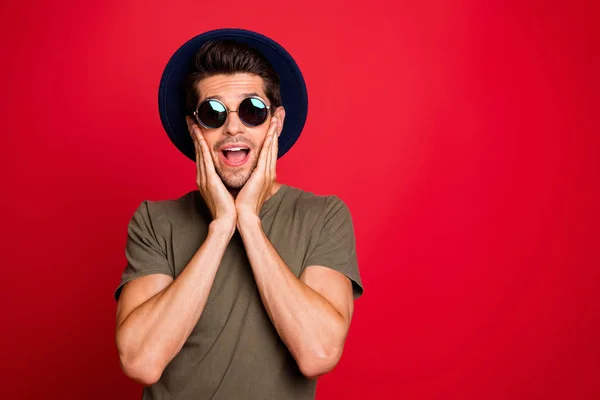 Incredibile ragazzo mani su guance incredibile spazio notizie indossare vintage cappello sole specs e t-shirt isolato su sfondo rosso — Foto Stock