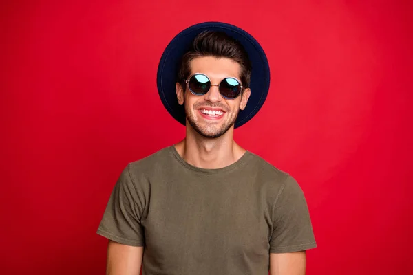 Foto de macho chico radiante sonrisa usar azul vintage sombrero sol especificaciones y gris camiseta aislada sobre fondo rojo —  Fotos de Stock