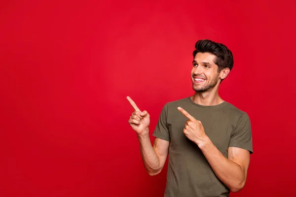Foto de tipo macho indicando dedos en las especias bajas de compras usan camiseta gris aislada sobre fondo rojo —  Fotos de Stock