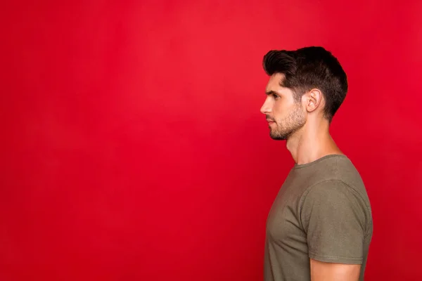 Profile photo of macho guy looking empty space wear grey t-shirt isolated on red background