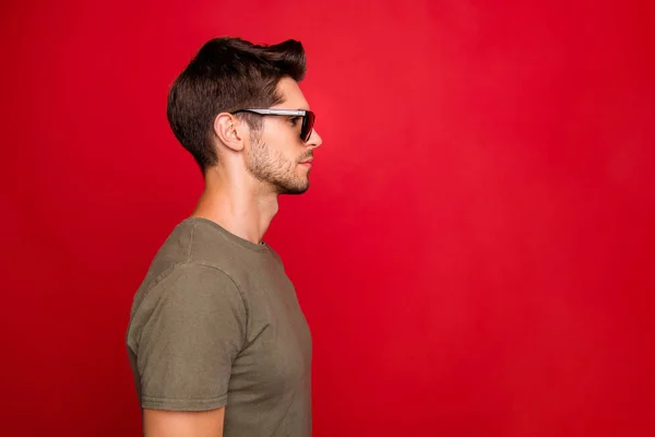 Foto de perfil de chico increíble buscando espacio vacío no sonriente desgaste camiseta gris aislado sobre fondo rojo —  Fotos de Stock