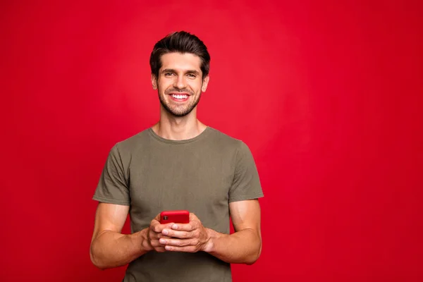 Parlak kırmızı arka plan üzerinde izole modern telefon elleri rahat kıyafet tutan inanılmaz adam Closeup fotoğraf — Stok fotoğraf