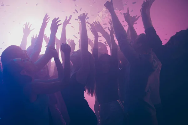 Close up foto di molte persone festive eccitate ballare clubbing viola luci coriandoli nebbia nightclub mani sollevato lucido formale-wear — Foto Stock