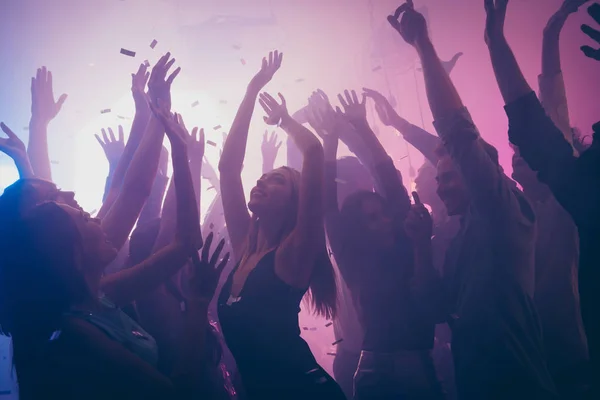 Foto di molti eventi di compleanno persone che ballano luci viola coriandoli volare godono di mani da discoteca sollevato abbigliamento formale — Foto Stock