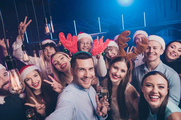 Self-portrait of nice-looking attractive lovely cheerful cheery positive excited glad ladies and guys having fun chill out showing v-sign symbol at luxury fogged nightclub indoors