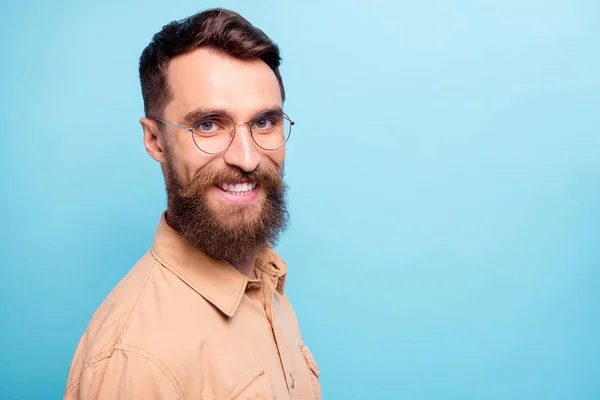 Foto girada de homem encantador olhando com sorriso radiante vestindo camisa marrom isolado sobre fundo azul — Fotografia de Stock