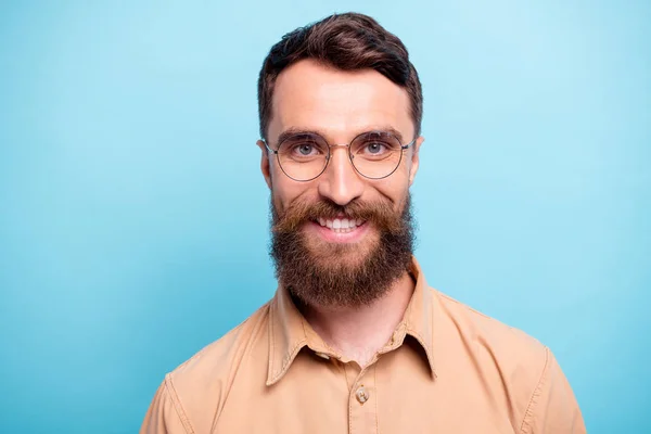 Close up foto de homem encantador olhando com o sorriso dos dentes usando camisa marrom isolado sobre fundo azul — Fotografia de Stock