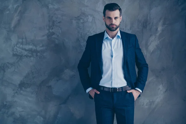 Retrato del magnífico empresario soñador mirando poniendo sus manos en el bolsillo usando pantalones ropa formal aislado sobre fondo gris — Foto de Stock