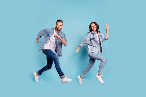 Tamanho total do corpo foto de casal regozijando de amigos correndo para shopping center para vendas, enquanto isolado com fundo azul — Fotografia de Stock