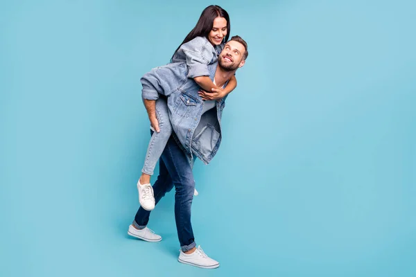 Foto de tamaño completo de personas encantadoras abrazando cerdito-respaldo usando chaquetas vaqueros vaqueros aislados sobre fondo azul — Foto de Stock