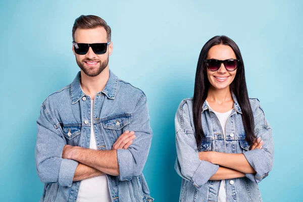 Portret van charmante kerel en meisje met lang haar kruis hun handen slijtage denim jeans jassen hebben brillen brillen geïsoleerd over blauwe achtergrond — Stockfoto
