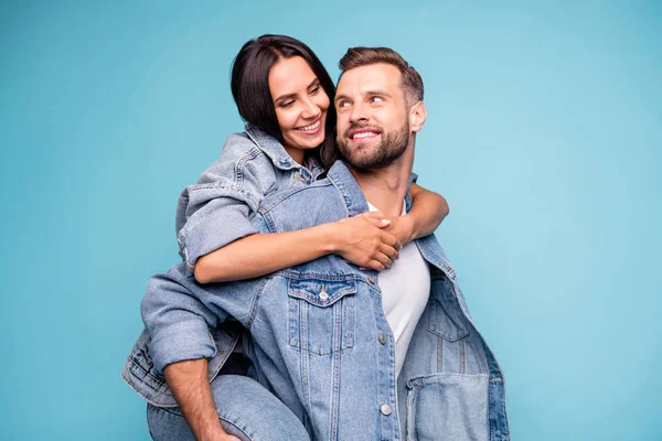 Porträt eines charmanten Paares, das sich umarmt und Jeans auf blauem Hintergrund trägt — Stockfoto