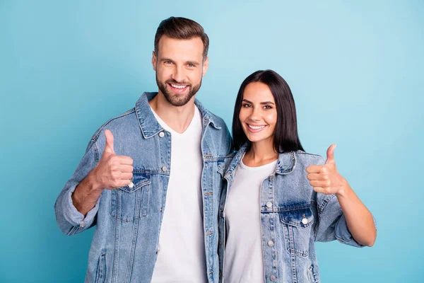 Retrato de cónyuges encantadores mostrando el pulgar hacia arriba usando vaqueros aislados sobre fondo azul —  Fotos de Stock