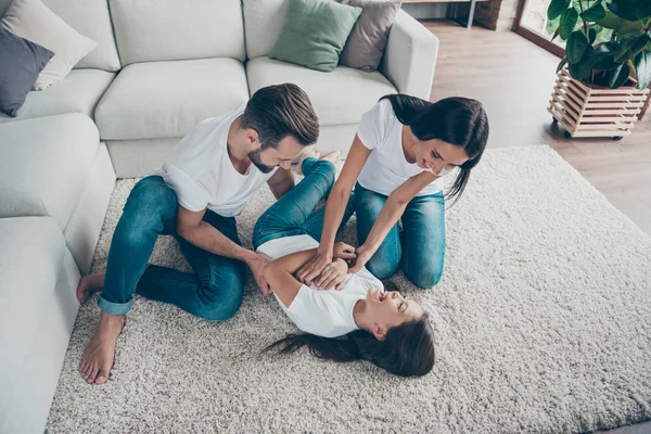 Nice attractive lovely cheerful cheery funky funny positive family wearing casual white t-shirts jeans having fun fooling on carpet floor at industrial loft style interior living-room — Stock Photo, Image