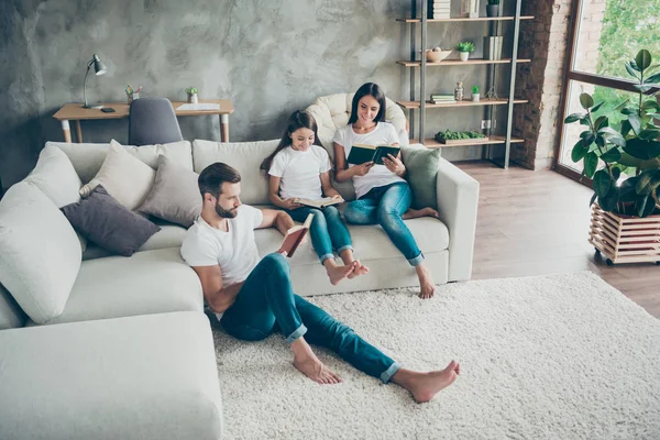 Mooie aantrekkelijke mooie charmante vriendelijke gericht vrolijk vrolijke idyllische familie dragen casual witte t-shirts jeans lezing boek hobby op industriële loft stijl interieur woonkamer indoor — Stockfoto