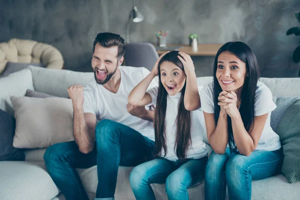 Portrait of nice attractive lovely winsome cheerful cheery funny family wearing casual white t-shirts jeans denim sitting on divan having fun accomplishment indoors apartment — Stock Photo, Image