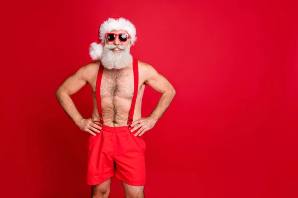 Portret van Hie hij leuke aantrekkelijke vrolijke inhoud gespierde funky grijs harige macho handen op heupen Holly Jolly Winter Kerst doop geïsoleerd over heldere levendige glans rode achtergrond — Stockfoto