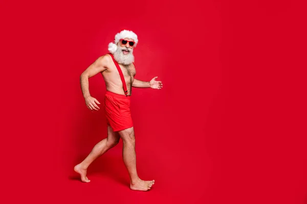 Comprimento total do corpo tamanho vista do seu ele agradável atraente alegre positivo feliz ajuste cinza de cabelos homem se divertindo azevinho alegre correndo viagem isolado sobre brilhante vívido brilho vermelho fundo — Fotografia de Stock