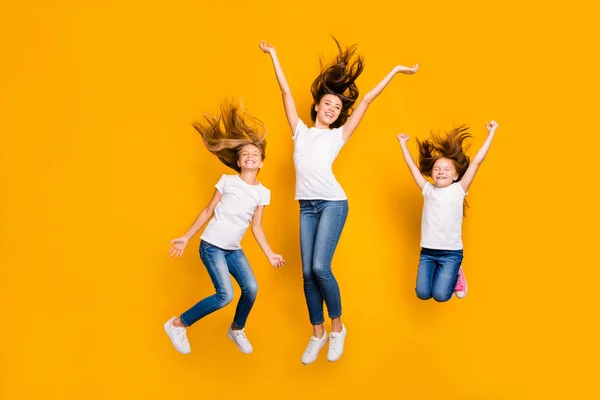 Ganzkörper-Foto von drei lustigen Damen springen hohe tragen Freizeitkleidung isoliert gelben Hintergrund — Stockfoto