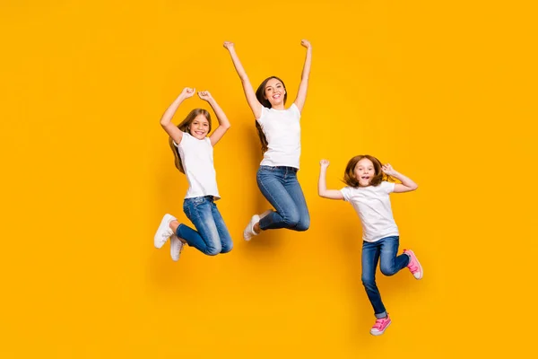 Ganzkörper-Foto von drei Damen springen hohe Ausgaben Wochenende tragen lässige Kleidung isoliert gelben Hintergrund — Stockfoto