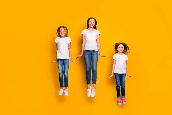 Foto completa di tre signore che saltano alta usura vestiti casual isolato sfondo giallo — Foto Stock