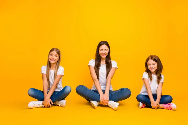 Foto von erstaunlichen verschiedenen Alters Damen sitzen Boden mit überkreuzten Beinen tragen lässige Kleidung isoliert gelben Hintergrund — Stockfoto