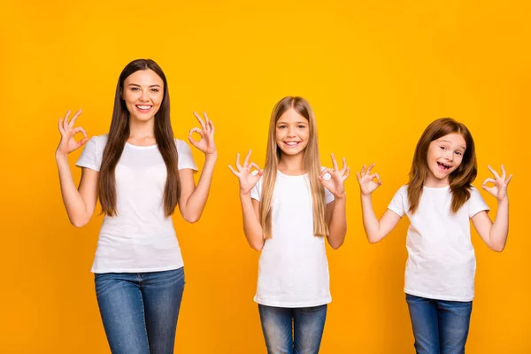 Divertido tres hermanas damas de la mano en okey símbolos desgaste casual traje aislado amarillo fondo —  Fotos de Stock