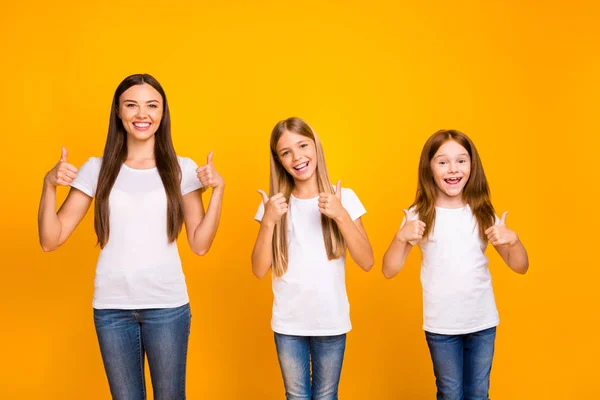 Красивые три сестры дамы давая качественное одобрение на новый испытанный продукт износа повседневной одежды изолированный желтый фон — стоковое фото