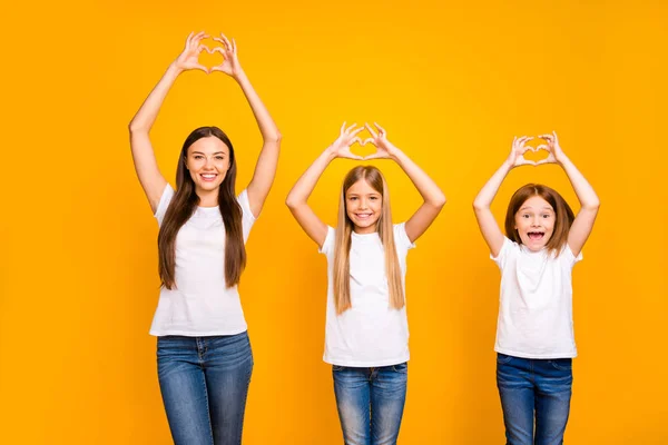 Pretty sister ladies meet holidays together making heart figure with hands wear casual outfit isolated yellow background — ストック写真