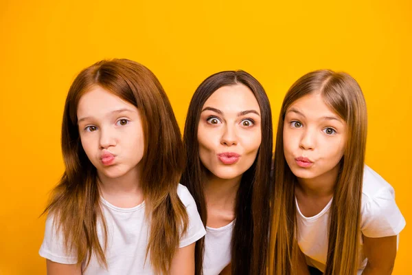 Foto von drei koketten Schwester Damen senden Luftküsse tragen lässige weiße T-Shirts isoliert gelben Hintergrund — Stockfoto