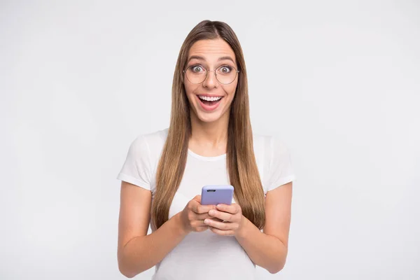 Mooie dame houden telefoon in handen slijtage specs en casual t-shirt geïsoleerd witte achtergrond — Stockfoto